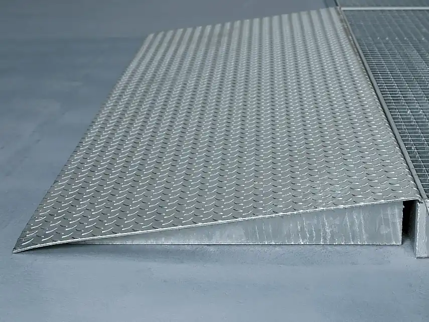 Seitenansicht einer Auffahrrampe aus 5 mm Tränenblech, die an einer flachen AUffangwanne befestigt ist.